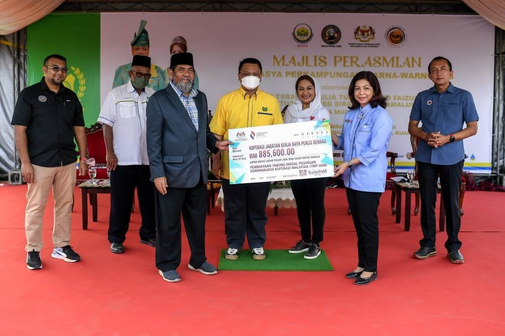 Raja Muda of Perlis Tuanku Syed Faizuddin Putra Jamalullail (fourth from right) witnessed Entrepreneur Development and Cooperatives Ministry secretary general Datuk Seri Suriani Ahmad handing over a cheque and certificate of recognition as the state's best cooperative to representatives of the Koperasi JKR Perlis Berhad during the Temasya Perkampungan Warna-Warni organised by the Malaysian Four-Wheel Drive Association at Dataran Semarak, Kampung Sebarang Ramai in Kuala Perlis today. - BERNAMA