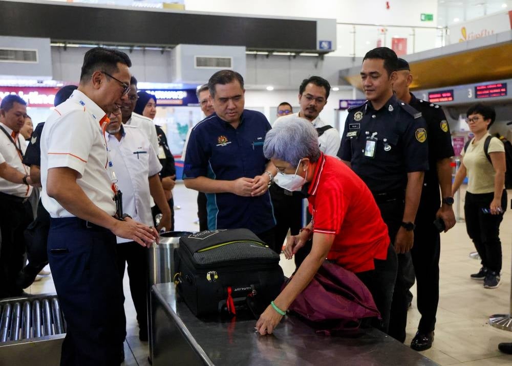 Transport Minister Anthony Loke Siew Fook (centre) takes a closer look at operations at the Sultan Abdul Aziz Shah International Airport in Subang after holding a press conference on a transformation plan that will see the airport turned into a regional aviation hub. - BERNAMA 