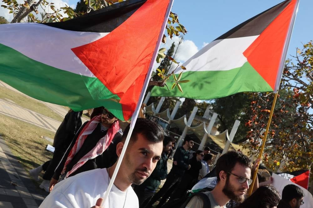 ILLUSTRATIVE PURPOSES. Arab-Israeli students and activists wave the Palestinian flag during a protest against the Israeli army operation in the West Bank city of Jenin, at the Tel Aviv University campus on January 30, 2032. (Photo by JACK GUEZ / AFP)