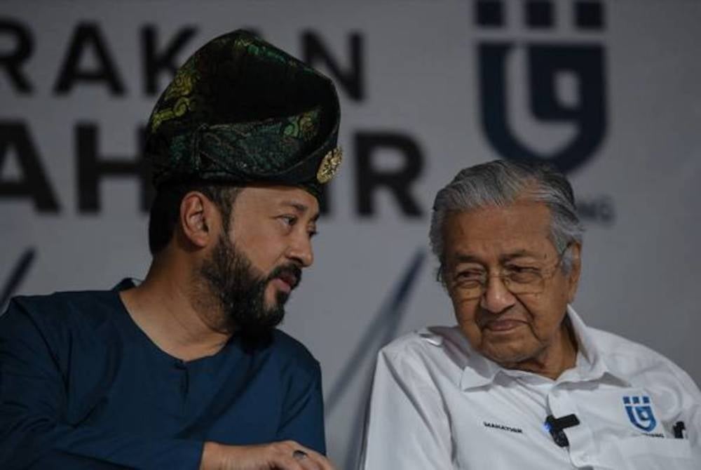 Dr Mahathir (right) and his son Mukhriz (left).