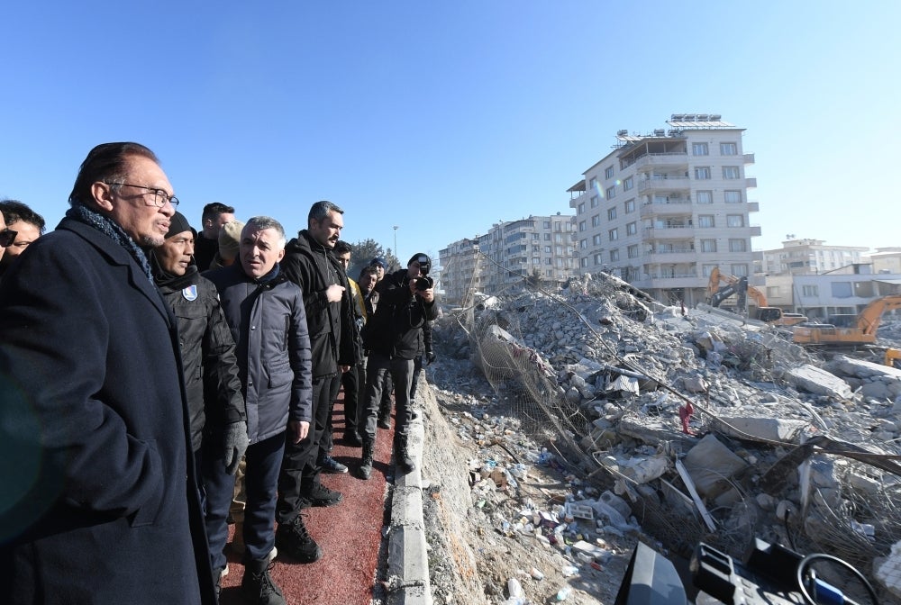 Anwar (left) looking at the rubbles post-earthquake during his visit to Malaysian SAR Operations Centre in Nurdagi, Gaziantep on Wednesday. (Photo by BERNAMA)