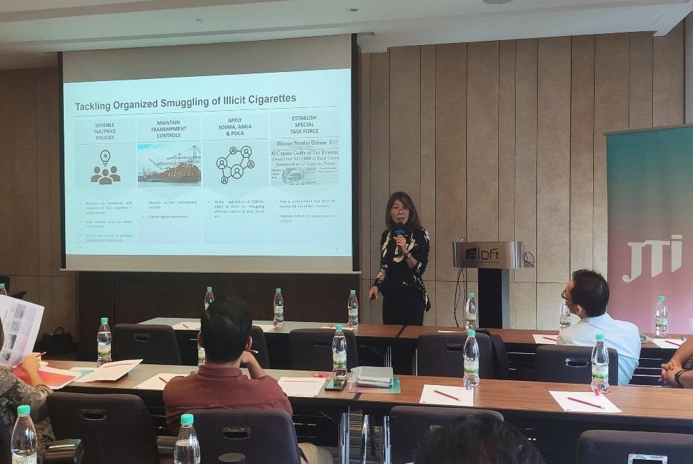 Japan Tobacco International (JTI) Malaysia general manager Khoo Bee Leng (standing) speaking at the press conference. - SYDI ALIF