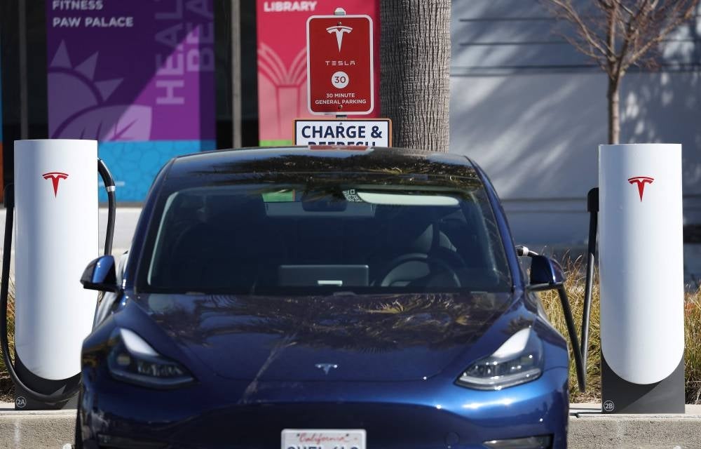 A Tesla car sits at a Tesla Supercharger station in Sausalito, California, United States on Feb 15. Electric car company Tesla announced that it will recall over 360,000 units of its electric cars to fix self-driving software malfunctions. - AFP