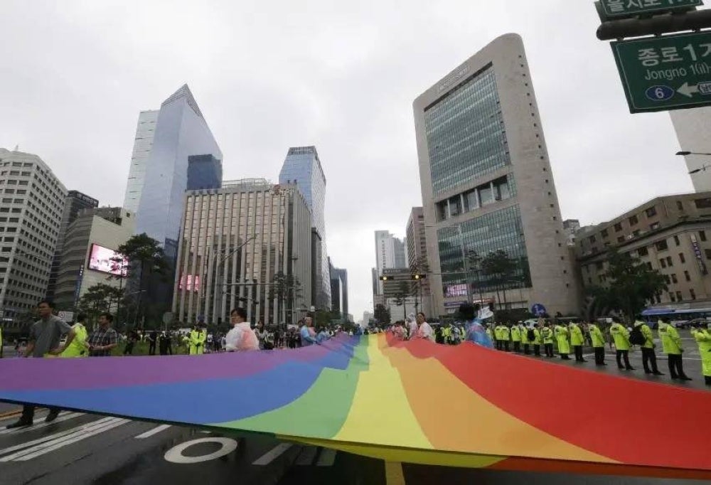 Participants march with a rainbow flag during a Pride parade in Seoul, South Korea, July 15, 2017. © 2017 AP Photo/Ahn Young-joon.