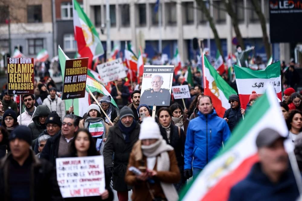 Demonstrators hold Iranian flag as they take part during a protest supporting Iranian resistance movement in Brussels on Feb 20. - AFP