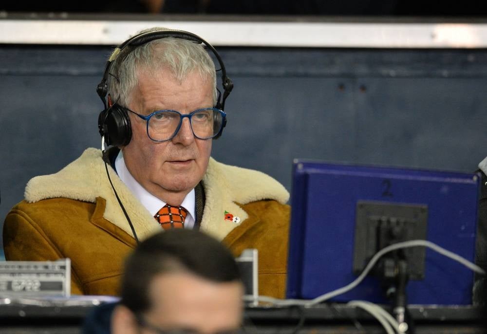 In this file photo taken on Nov 2, 2015, BBC commenatator John Motson watches the English Premier League football match between Tottenham Hotspur and Aston Villa at White Hart Lane in north London. Motson has died at the age of 77. - AFP
