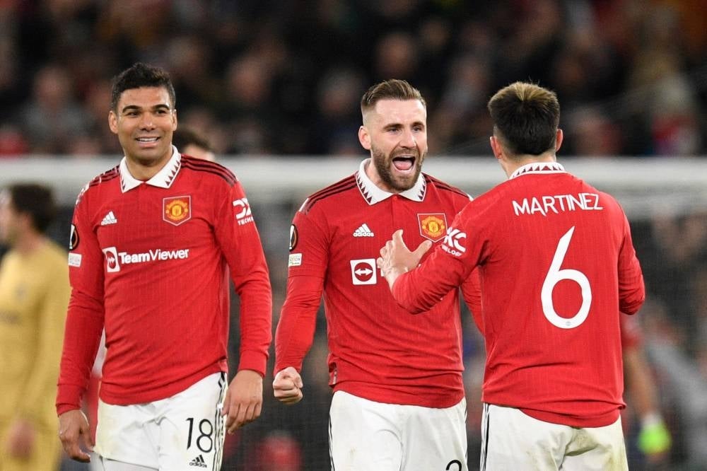 Manchester United's Brazilian midfielder Casemiro (left), English defender Luke Shaw and Argentinian defender Lisandro Martinez celebrate at the end of the UEFA Europa league knockout round play-off second leg football match between Manchester United and FC Barcelona at Old Trafford in Manchester on Feb 23, which Manchester United won 2-1 to advance to the Europa League quarterfinals. Manchester United face Newcastle United in the English League Cup final at Wembley tonight. - AFP