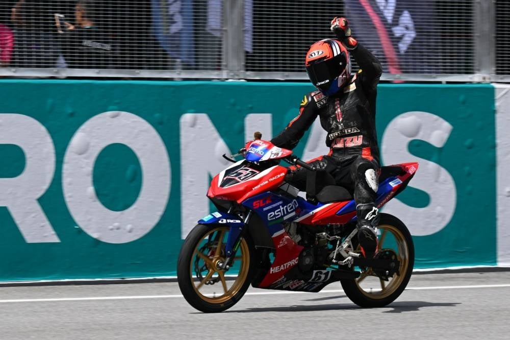 Shahrol Syazras Shahrol Yuzy crosses the finish line after surging ahead in the final lap to take the first win of the season in the CP150 class at the Sepang Crictui yesterday.