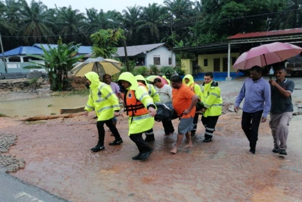 The deceased being carried by personnel. - Kluang district police Facebook