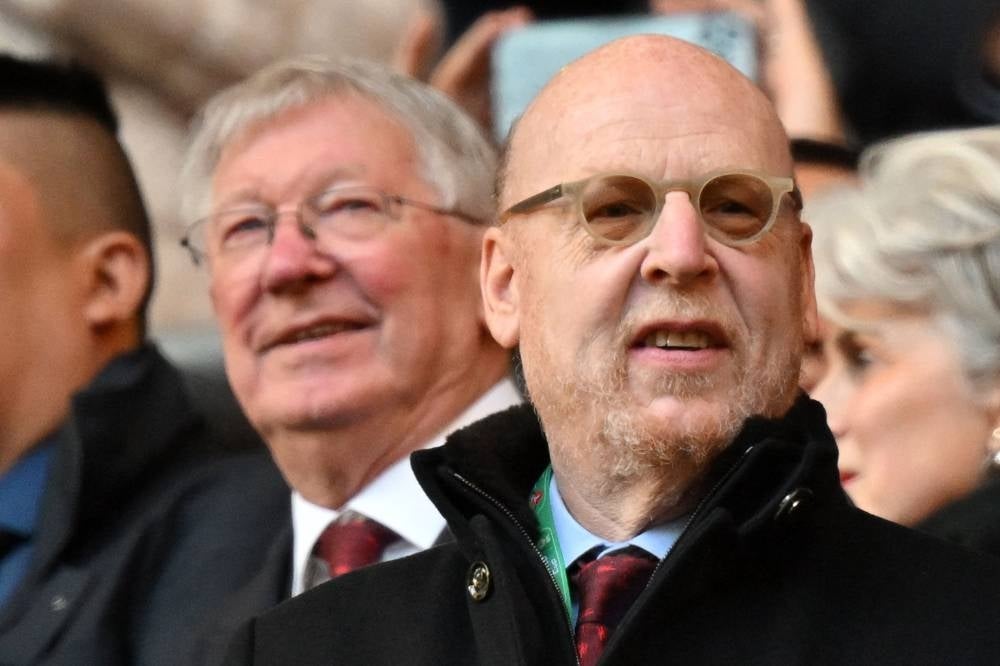 Manchester United's former manager Alex Ferguson (L) and US co-chairman Avram Glazer wait for kick off ahead of the English League Cup final match between Manchester United and Newcastle United at Wembley Stadium on Feb 26. Manchester United's owners, the Glazer family, are under pressure to sell the club, with several official bids incoming. - AFP
