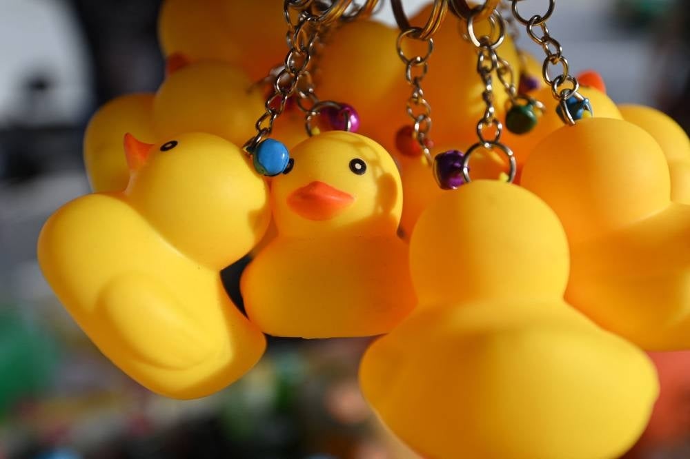 In this file photo taken on Dec 1, 2020 keychains in the form of yellow rubber ducks, associated with the pro-democracy movement, are displayed for sale during a protest outside the Ministry of Education in Bangkok. - A Thai man has been jailed for two years for selling calendeas featuring satirical yellow rubber ducks that prosecutors said defamed the royal family. - AFP