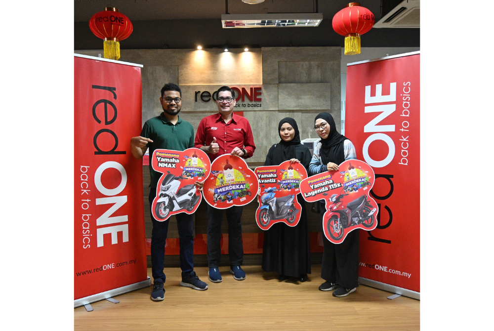 From left: Muhammad Afiq Rizqin bin Mohamad Rapi, Senang Menang Merdeka contest winner, Farid Yunus, Chief Executive Officer, redONE Network Sdn Bhd, Nuraini Binti Mohamad Zariman, Senang Menang Merdeka contest winner, and Noor Amierazatyka binti Ayob Senang Menang Merdeka contest winner, posing with cut-outs of their prizes at redONE Network Sdn Bhd HQ in Puchong.