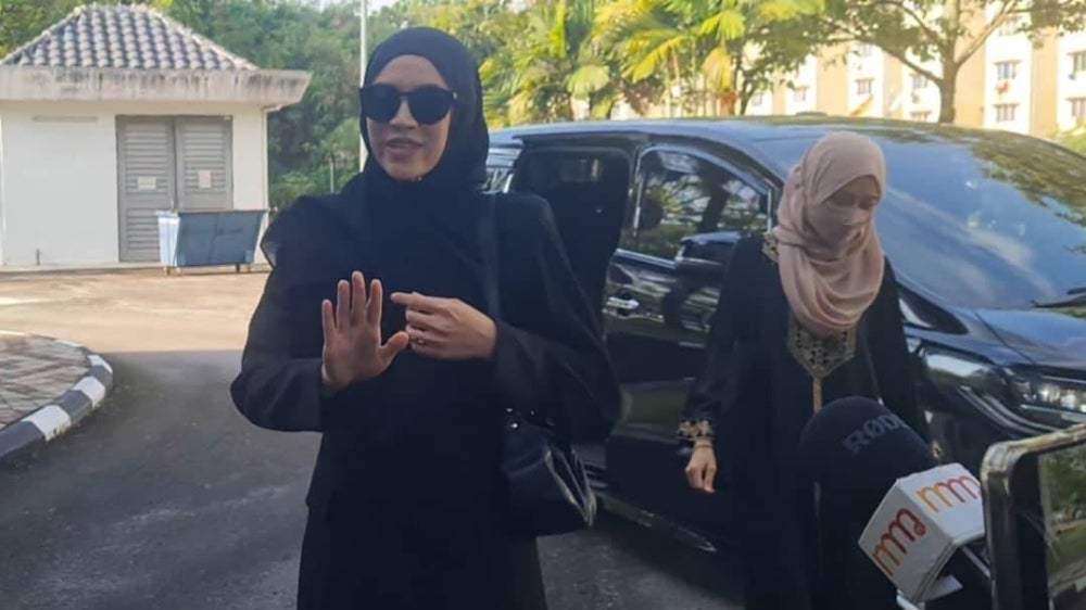 Diana Danielle arrived in court wearing black jubah (robe) accompanied by her assistant and bodyguard.