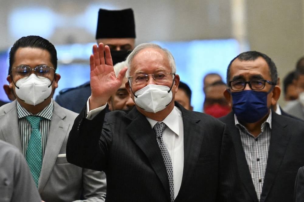 Datuk Seri Najib Razak waves as he arrived at the Federal Court in Putrajaya on Aug 23, 2022. - (Photo by MOHD RASFAN / AFP)