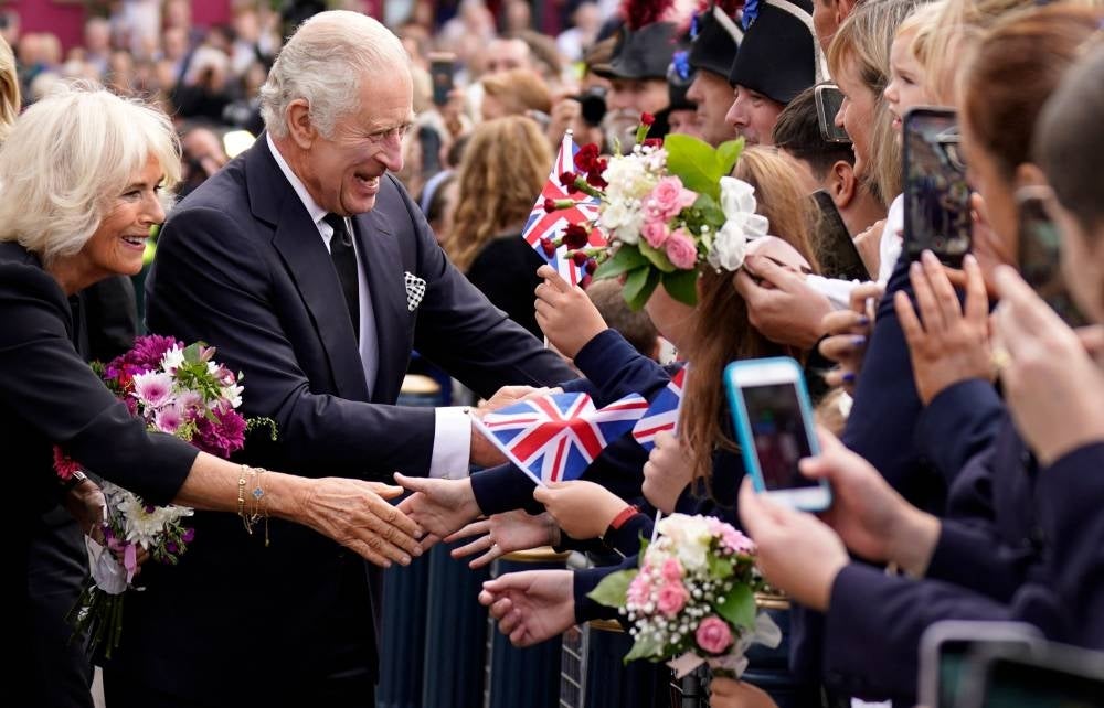 Britain's King Charles III and Camilla, the queen consort, greet the crowd as they arrive at Hillsborough Castle in Belfast, during his visit to Northern Ireland in September - AFP 