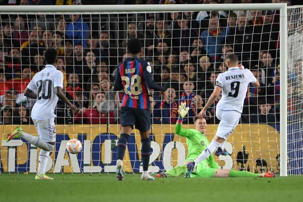 Real Madrid's French forward Karim Benzema (R) scores his team's fourth goal during the Copa del Rey (King's Cup) semi-final second leg football match between FC Barcelona and Real Madrid CF at the Camp Nou stadium in Barcelona on April 5. - Pic: AFP