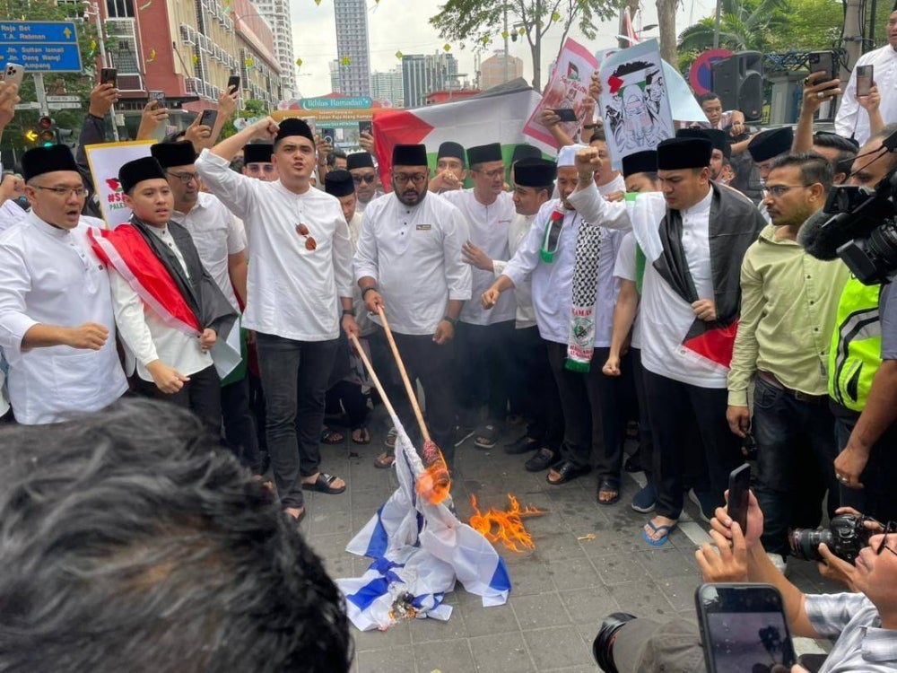 Umno Youth burns the Israeli flag to show solidarity with Palestinians during the Solidarity Rally with Palestine at Masjid Jamek, Kampung Baru.