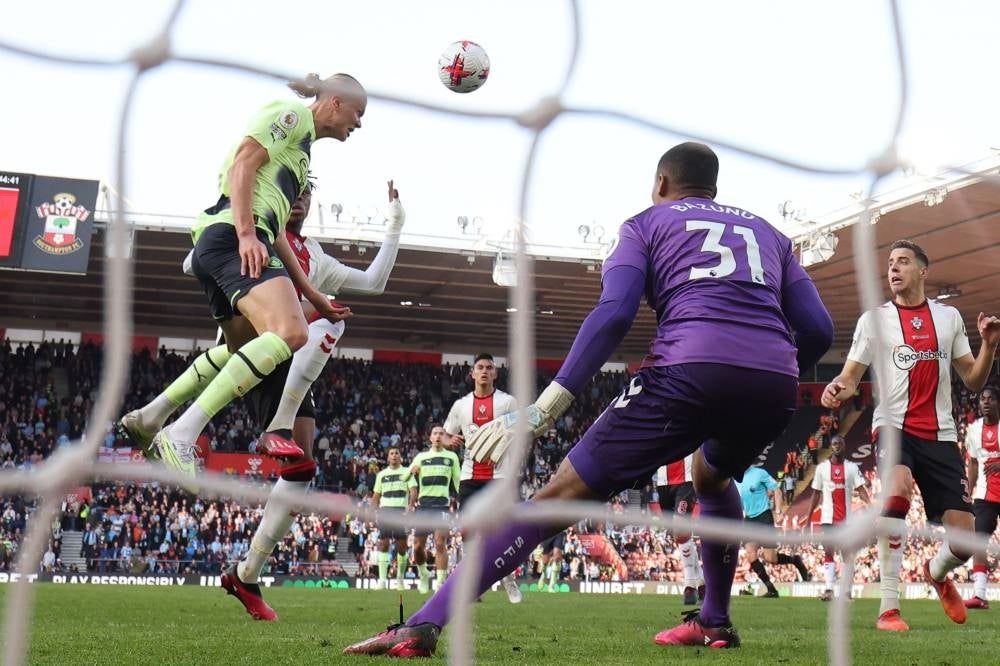 Manchester City's Norwegian striker Erling Haaland (L) jumps to head home the opening goal during the English Premier League football match between Southampton and Manchester City at St Mary's Stadium in Southampton, southern England on April 8. - Pic: AFP