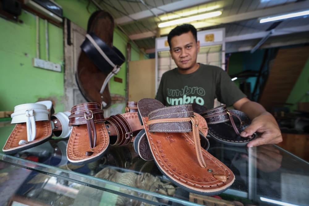 Traditional capal maker Badril Shahidan Hashim, 42, is busy meeting demand for his 'Capal Jago Gemilang' brand of traditional footwear which is especially popular during the Hari Raya Aidilfitri festive period, with over 300 orders needing to be delivered ahead of the festivities. - Pic: BERNAMA 