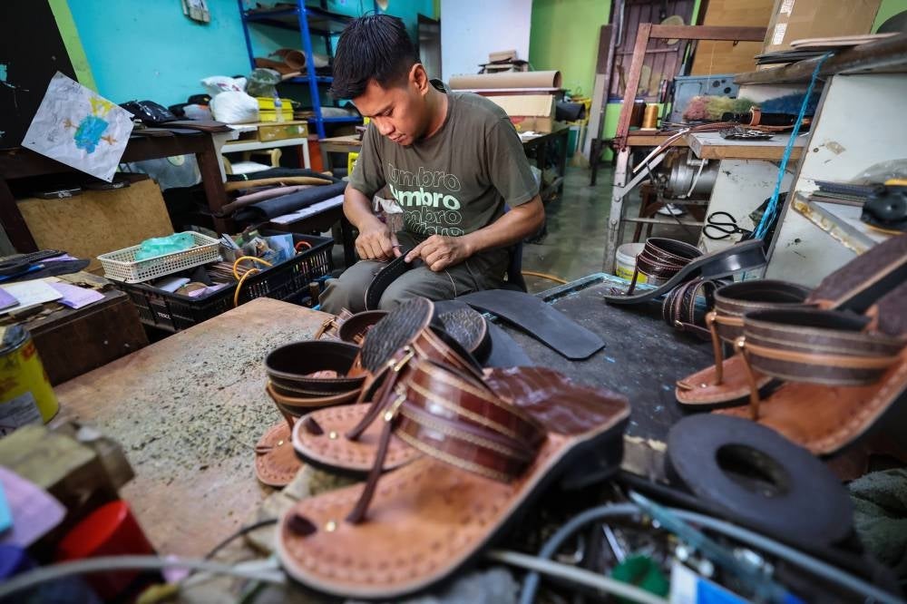Traditional capal maker Badril Shahidan Hashim, 42, is busy meeting demand for his 'Capal Jago Gemilang' brand of traditional footwear which is especially popular during the Hari Raya Aidilfitri festive period, with over 300 orders needing to be delivered ahead of the festivities. - Pic: BERNAMA 