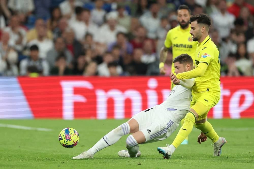 Real Madrid's Uruguayan midfielder Federico Valverde (L) vies with Villarreal's Spanish midfielder Alex Baena during the Spanish league football match between Real Madrid CF and Villarreal CF at the Santiago Bernabeu stadium in Madrid on April 8. Baena was allegedly struck in the face by Uruguay international Valverde after the champions' 3-2 defeat in La Liga, with the Madrid player waiting for him by the Villarreal team bus. - Pic: AFP