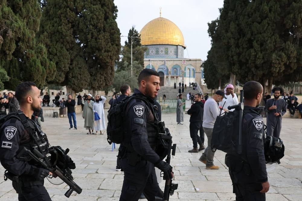 Jewish visitors walk protected by Israeli security forces at the Al-Aqsa mosque compound, also known as the Temple Mount complex to Jews, in Jerusalem on April 9, 2023, during the Muslim holy fasting month of Ramadan, also coinciding with the Jewish Passover holiday. (Photo by AHMAD GHARABLI / AFP)