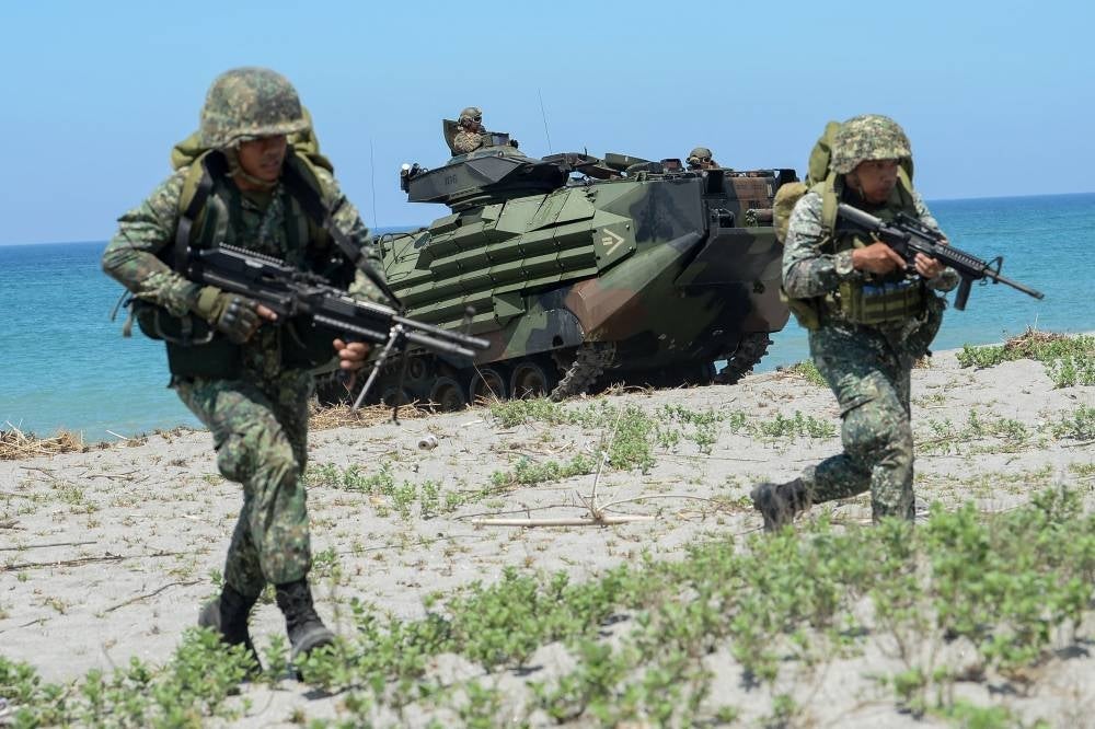 (FILES) In this file photo taken on October 6, 2018, Philippine marines take position next to US marines' Amphibious Assault Vehicles (AAV) during an amphibious landing exercise at the beach of the Philippine navy training centre facing the South China Sea in San Antonio town, Zambales province. - FOCUS by Allison JACKSON