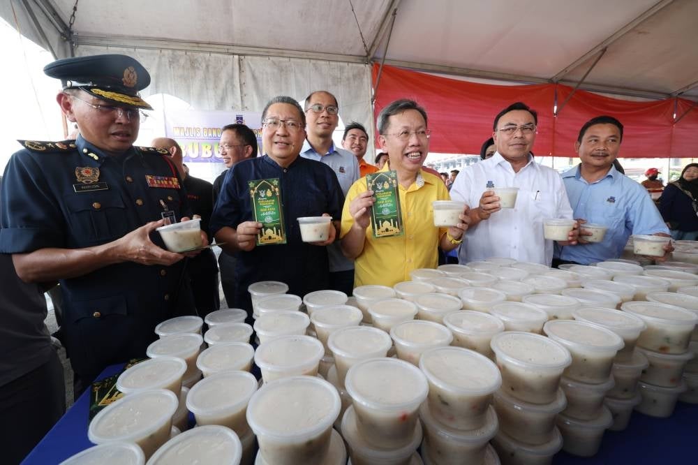 Sarawak Deputy Premier Datuk Seri Dr Sim Kui Hian (centre) distributing leaflets to the public after officiating the 2023 Aidilfitri Season Fire Safety Campaign at the Ramadan Bazaar, Stutong Community Market today - FILEPIC 