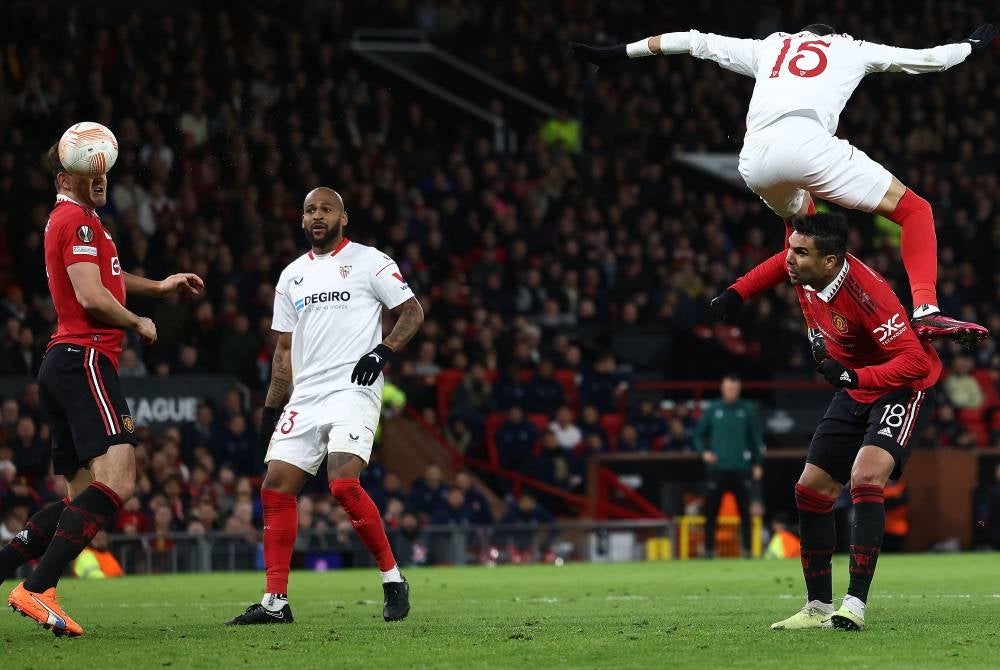 Sevilla's Moroccan forward Youssef En-Nesyri headers the ball to score a second goal, deflected in for an own goal off of Manchester United's English defender Harry Maguire (L) during the UEFA Europa league quarter-final, first leg football match between Manchester United and Sevilla at Old Trafford stadium in Manchester, north west England, on April 13. - Pic: AFP
