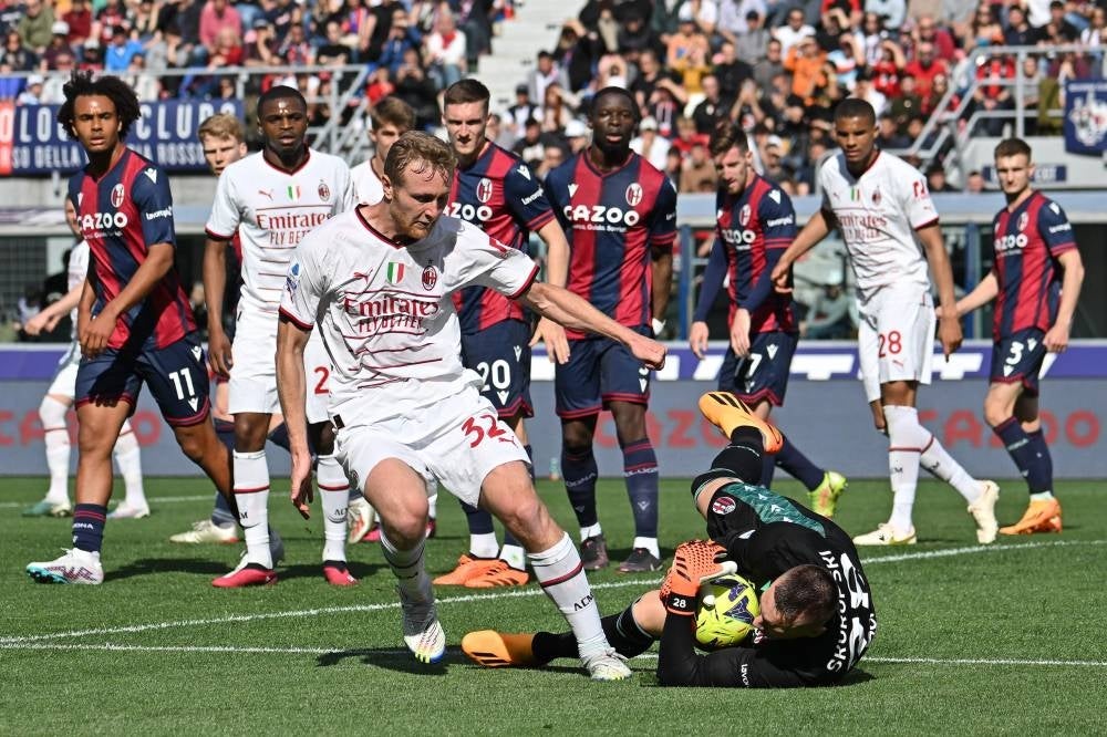 Bologna's Polish goalkeeper Lukasz Skorupski (R) stops the ball against AC Milan's Italian midfielder Tommaso Pobega during the Italian Serie A football match between Bologna and Milan AC at the Renato-Dall'Ara stadium in Bologna, on April 15. - AFP