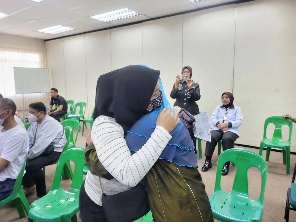 Mariam (right) hugging her sister when she was informed that she was among the inmates given an early release from their sentence through the Licensed Prisoner Release Programme at the Kota Kinabalu Central Prison mini hall.