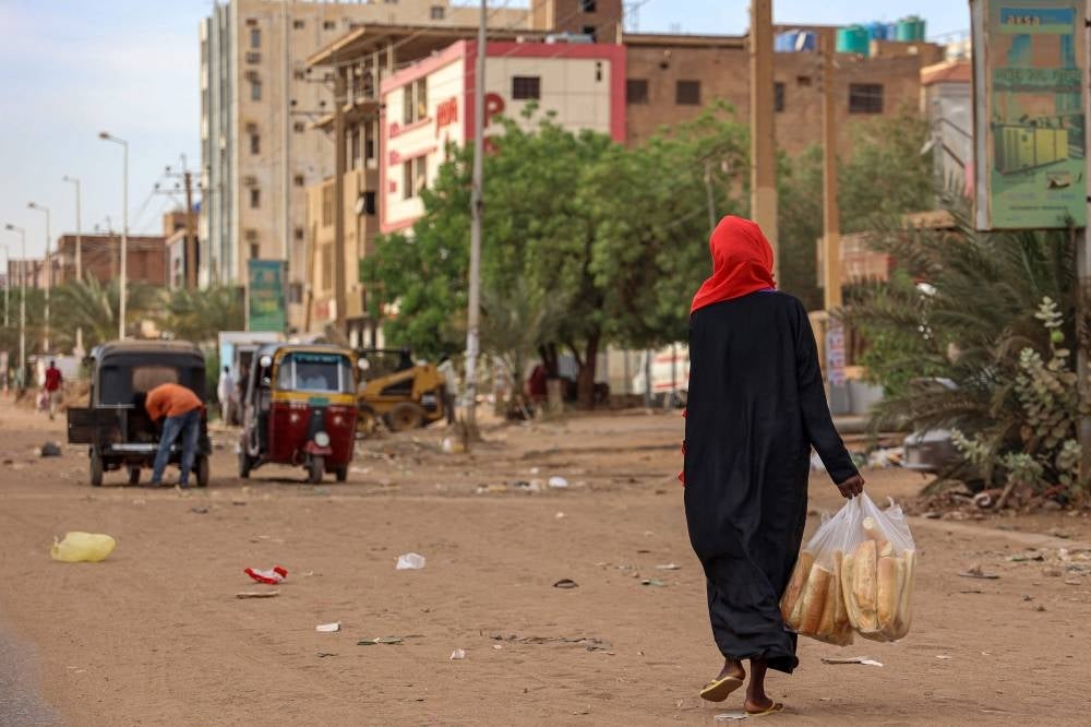 A woman walks with bags of bread along a street in Khartoum on April 18,. - Explosions rocked the Sudanese capital Khartoum on April 18, the fourth day of fighting that has claimed nearly 200 lives despite growing international calls for an end to hostilities that have spawned increasing lawlessness.
Thousands of residents on Wednesday fled Sudan's capital, where witnesses said bodies lay in the street from fighting between the army and paramilitaries after a 24-hour truce failed to take hold. - Pic: AFP
