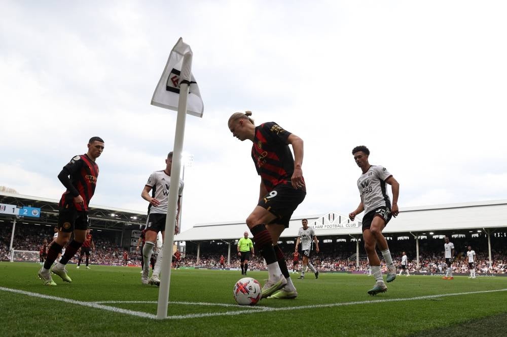 Manchester City's Norwegian striker Erling Haaland (C) keeps the ball in the corner late on in the game during the English Premier League football match between Fulham and Manchester City at Craven Cottage in London on April 30. - Man City won the game 2-1. - AFP