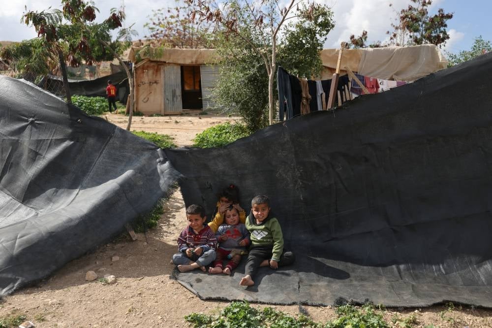 Palestinian children sit outside their home in the Bedouin village of Khan al-Ahmar in the occupied West Bank, near the east Jerusalem suburb of Abu Dis on Jan 30, 2023. - (Photo by AHMAD GHARABLI / AFP)