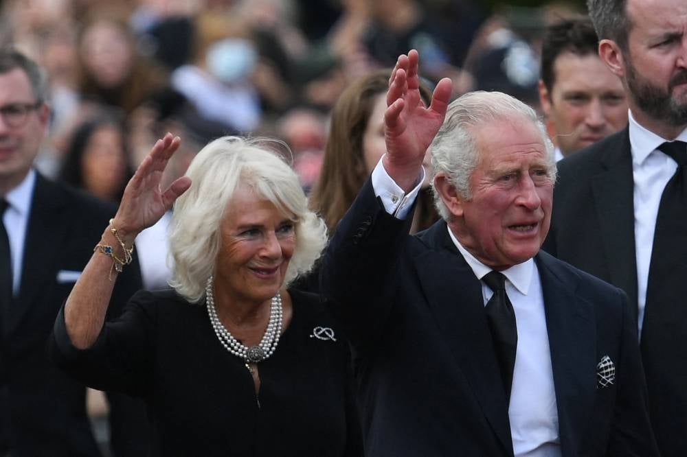 Photo taken on September 9, 2022 Britain's King Charles III (R) and Britain's Camilla, Queen Consort wave as they greet the crowd upon their arrival Buckingham Palace in London, a day after Queen Elizabeth II died at the age of 96. - Britain's first coronation in 70 years takes place on Saturday, with Charles III crowned king in an elaborate Christian ceremony steeped in solemn ritual and more than a millennium of history. - Photo by Daniel Leal / AFP)