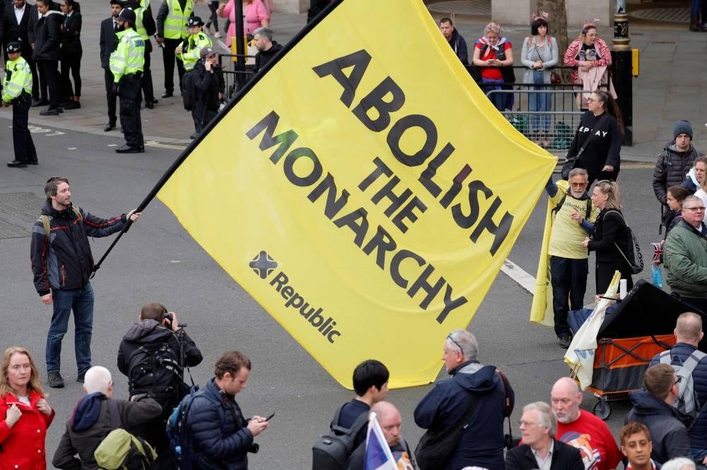 A protester holds a flag saying 'Abolish the Monarchy' in Trafalgar Square close to where Britain's King Charles III and Britain's Camilla, Queen Consort will be crowned at Westminster Abbey in central London on May 6, 2023. - The set-piece coronation is the first in Britain in 70 years, and only the second in history to be televised. Charles will be the 40th reigning monarch to be crowned at the central London church since King William I in 1066. Republican opponents who want an elected head of state plan to protest on the day with signs declaring "Not my king". (Photo by PIROSCHKA VAN DE WOUW / AFP)