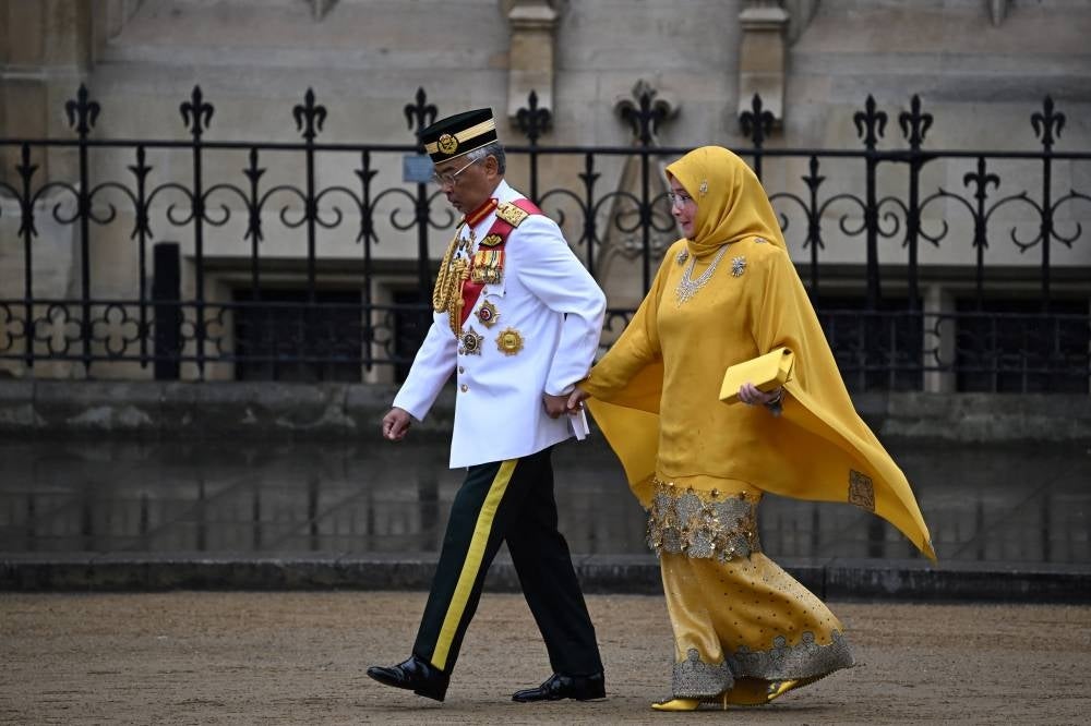 Yang di-Pertuan Agong Al-Sultan Abdullah Ri'ayatuddin Al-Mustafa Billah Shah and Raja Permaisuri Agong Tunku Azizah Aminah Maimunah Iskandariah arrive at Westminster Abbey in central London on May 6, 2023, ahead of the coronations of Britain's King Charles III and Britain's Camilla. - (Photo by PAUL ELLIS / AFP)