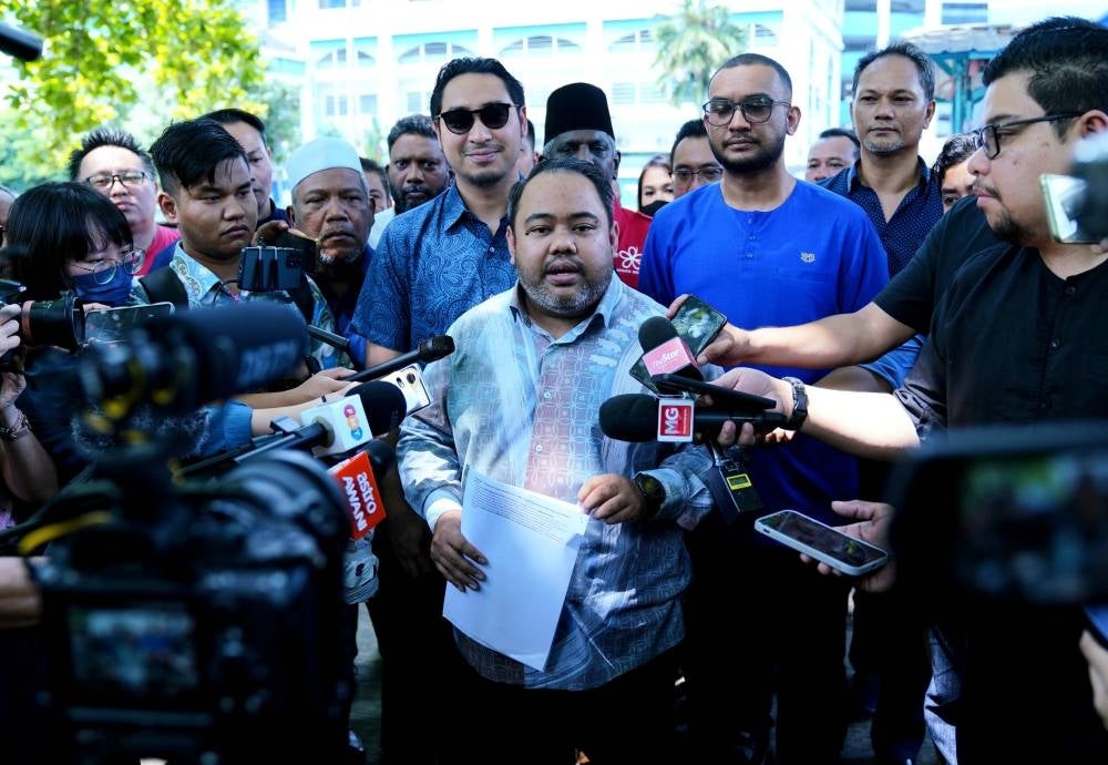 Opposition leader Datuk Seri Hamzah Zainudin's private secretary Ahmad Ikhwan Fadhli during a press conference after lodging a police report at Dang Wangi police headquarters to clear Hamzah's name. - Photo by MOHD HALIM ABDUL WAHID.