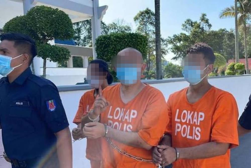 One of the suspects appeared cheerful while escorted by cops and even gestured signs like 'okay' and 'good' towards the reporters. - Astro Awani photo