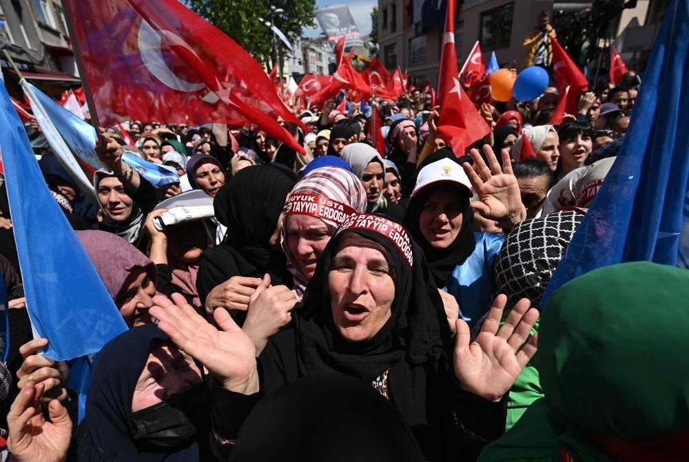 Supporters of the incumbent Turkish President, who runs for reelection, gesture and cheer as they gather for a rally in the Beyoglu district on the eve of the presidential and parliamentary elections, on the European side of Istanbul, on May 13, 2023. Erdogan warned his conservative supporters they could face reprisals should his secular rival rise to power in momentous weekend polls. Erdogan has been trying to rally his base ahead of elections that put his Islamic style of rule in the largest Muslim-majority member of NATO on the line. (Photo by OZAN KOSE / AFP)