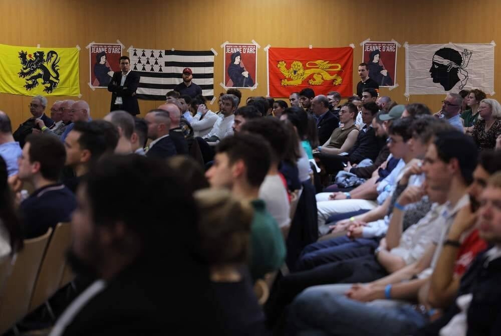 Attendees take part in a meeting named "France in danger" of the French far-right monarchist movement Action Francaise at the Espace Charenton in Paris, on May 13, 2023. Paris' administrative court suspended the ban placed by the Police Prefect on the event. (Photo by Thomas SAMSON / AFP)