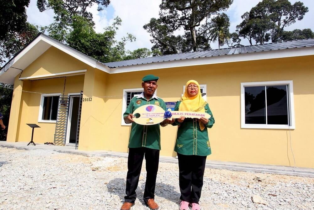 Retired Malaysian Armed Forces Commando Mohd Sobri Bakar, 63, (right) and his wife Zima Abu Talib, 54, are happy after receiving a new house at the ATM Veterans Initiative House Key Handover Ceremony conducted by the Director General of the Department of Veterans Affairs of the Malaysian Armed Forces (JHEV ATM) ) Major General Zambery Jefry Darus in Ulu Chepor today. - BERNAMA