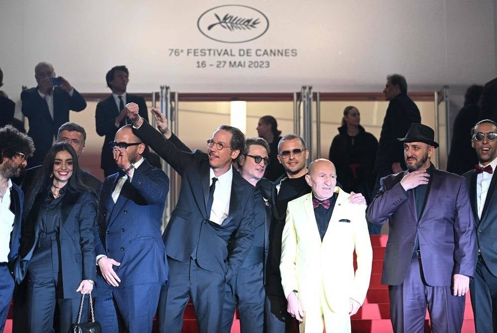 Actress Meriem Amiar (2L), French actor Reda Kateb (4L), French actor Benoit Magimel (C) and French-Algerian director Elias Belkeddar (C-R) pose as they arrive for the screening of the film "Omar la Fraise" (The King of Algiers) during the 76th edition of the Cannes Film Festival in Cannes, southern France, on May 20, 2023. (Photo by Patricia DE MELO MOREIRA / AFP)
