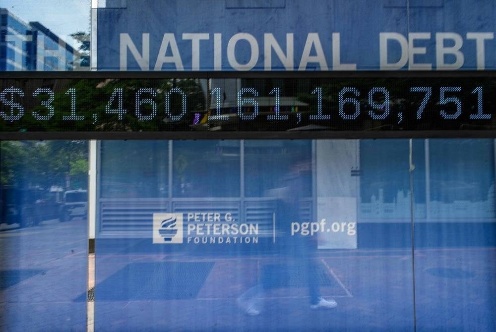 A digital display board at a bus shelter showing the national debt is seen in Washington, DC, on May 19, 2023. Republicans have paused crunch US debt default talks less than two weeks before a potentially catastrophic default, House Speaker Kevin McCarthy said Friday, citing lack of movement from Democrats. (Photo by Mandel NGAN / AFP)