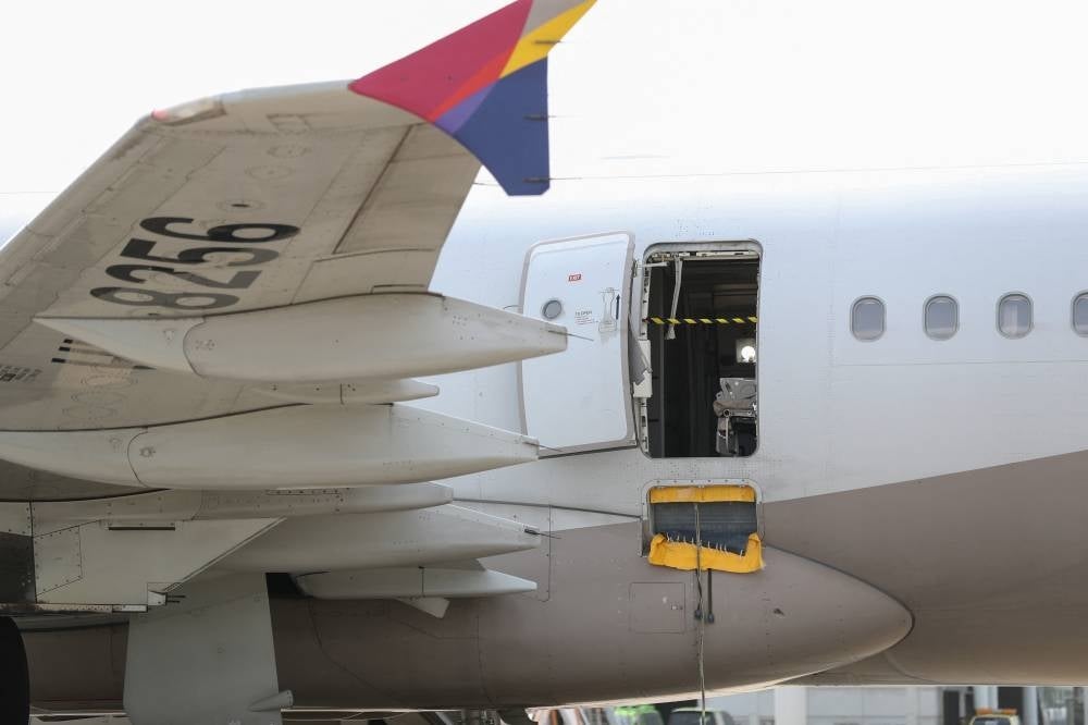 An opened door of an Asiana Airlines plane is seen at Daegu International Airport in Daegu on May 26, 2023, after it was manually opened by a passenger just 200 metres above the ground before landing causing some to have breathing difficulty but with no major injuries. - (Photo by YONHAP / AFP)