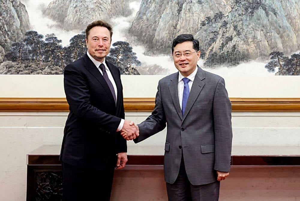 This handout picture taken and released by the Ministry of Foreign Affairs of the People's Republic of China on May 30, 2023 shows Tesla CEO Elon Musk (L) shaking hands with China's Foreign Minister Qin Gang during a meeting in Beijing. Elon Musk met Foreign Minister Qin Gang in Beijing on May 30, the ministry said, as the Tesla CEO embarks on his first trip to China in more than three years. (Photo by Handout / Ministry of Foreign Affairs of the People's Republic of China / AFP) / -----EDITORS NOTE --- RESTRICTED TO EDITORIAL USE - MANDATORY CREDIT "AFP PHOTO / Ministry of Foreign Affairs of the People's Republic of China " - NO MARKETING - NO ADVERTISING CAMPAIGNS - DISTRIBUTED AS A SERVICE TO CLIENTS