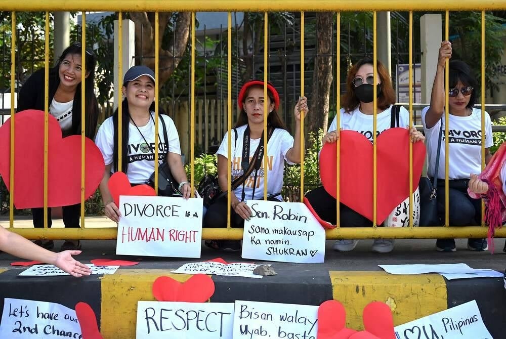 In this photo taken on February 14, 2023 shows pro-divorce protesters taking part in a demonstration on Valentine's Day in front of the Senate Building in Pasay, Metro Manila. The Philippines is the only place outside the Vatican where divorce is outlawed, with the Catholic Church -- which holds great influence on Philippine society -- opposing the practice as against its teachings. (Photo by JAM STA ROSA / AFP) / To go with "Philippines-divorce-religion-politics", FOCUS by Ara Eugenio