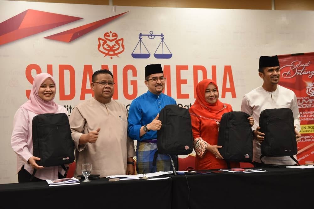 Umno secretary-general Datuk Asyraf Wajdi Dusuki (center) presents the official bag for the 6,341 representatives attending the PAU. - Photo by Sinar Harian/ Mohd Rafiq Redzuan Hamzah