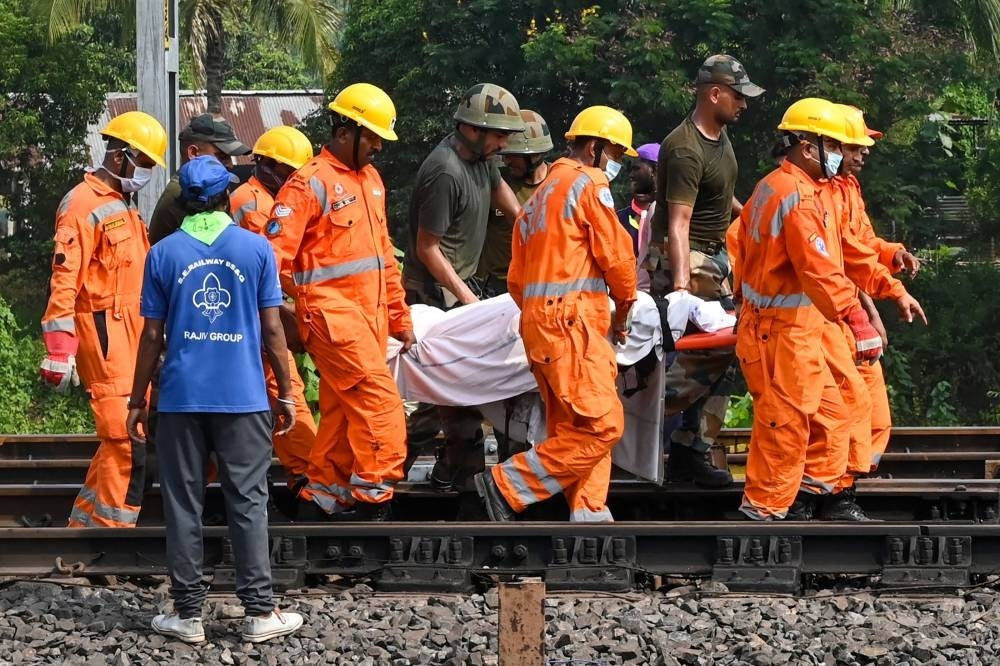 Rescue workers carry the body of a victim along the tracks at the accident site of a three-train collision near Balasore, about 200 km (125 miles) from the state capital Bhubaneswar in the eastern state of Odisha, on June 3, 2023. Photo by Dibyangshu Sarkar/AFP.