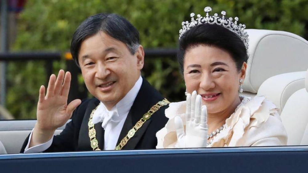 Japan’s Emperor Naruhito and Empress Masako wave during a royal parade in Tokyo. AFP.